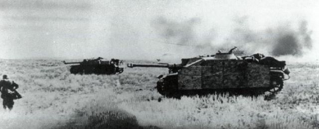 Cañones de asalto StuG III de la Das Reich avanzan por la estepa entre la descarga de artillería soviética. Julio 1943