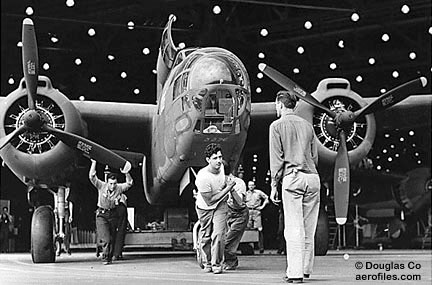 Trabajadores de la fábrica sacan un bombardero Douglas A-20 completo de la línea de ensamblaje en la planta de fabricación de Long Beach, en octubre de 1942